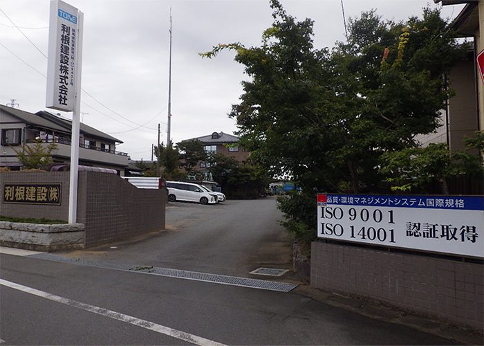 利根建設株式会社の社屋入口。看板にISO9001・ISO14001認証取得と掲げられている